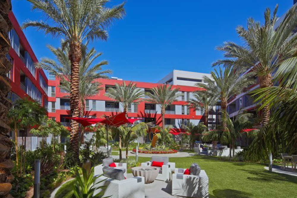 Outdoor seating with the view of the apartment building at The Marke Apartment Homes in Santa Ana, California