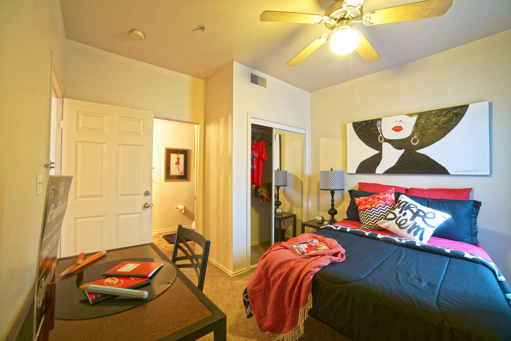 Apartment bedroom with closet and ceiling fan at The Quarters at Lawrence in Lawrence, Kansas