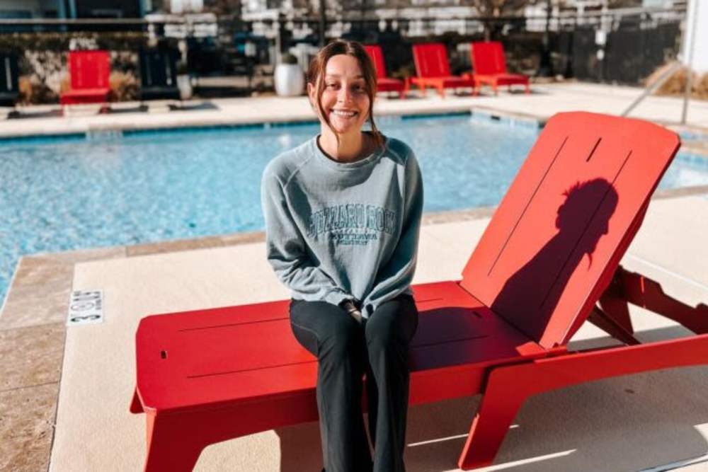 Resident sitting by the pool at The Landing at Fayetteville in Fayetteville, Arkansas