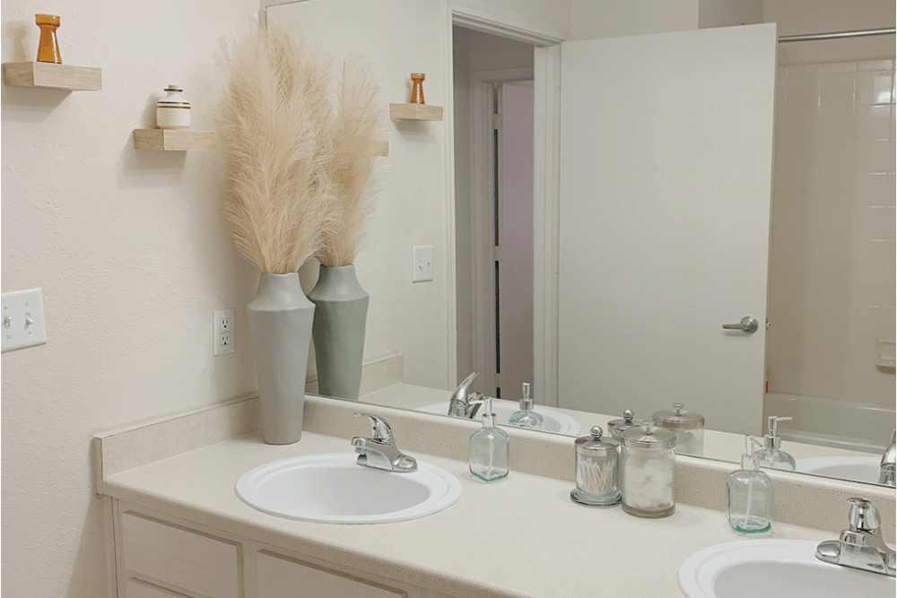 Bathroom with two sinks and large mirror at The Quarters at Lincoln in Lincoln, Nebraska