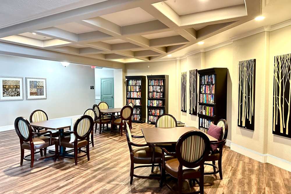 Game room with tables and chairs to play board games surrounded by bookshelves
