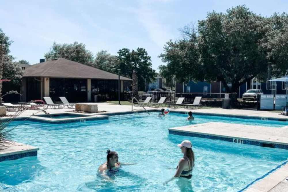 Residents playing in the pool at The Landing at College Station in College Station, Texas