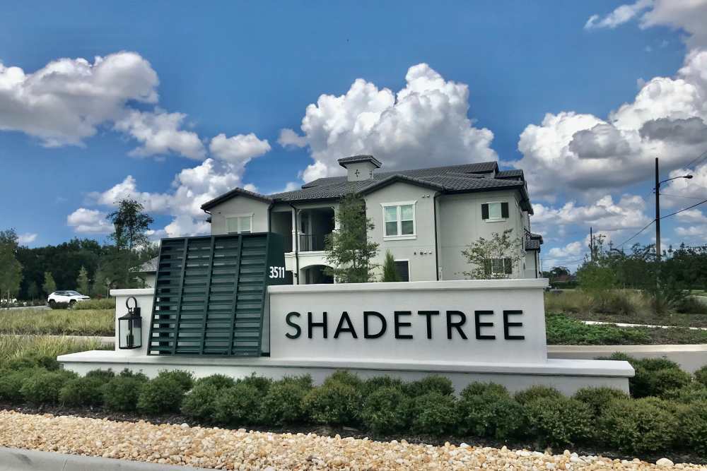 Front entrance sign of community grass at Shadetree Apartments in Ruskin, Florida