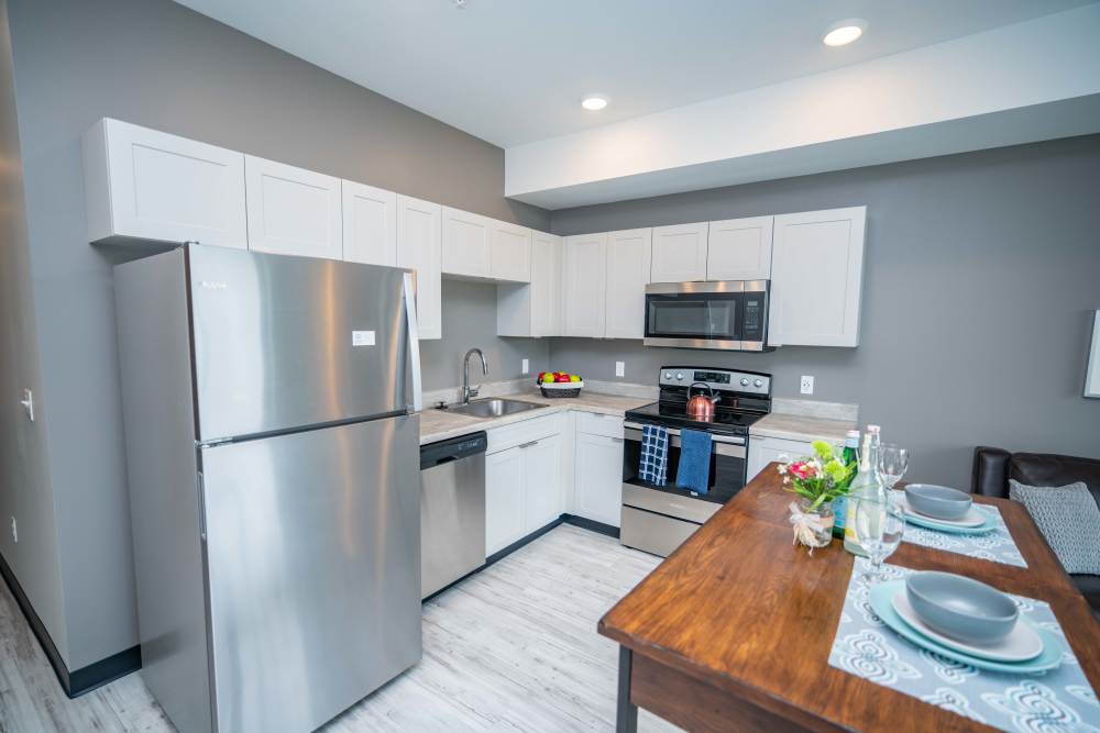 Spacious kitchen with sleek stainless-steel appliances and a dining table at Diamond Place I in Grand Rapids, Michigan