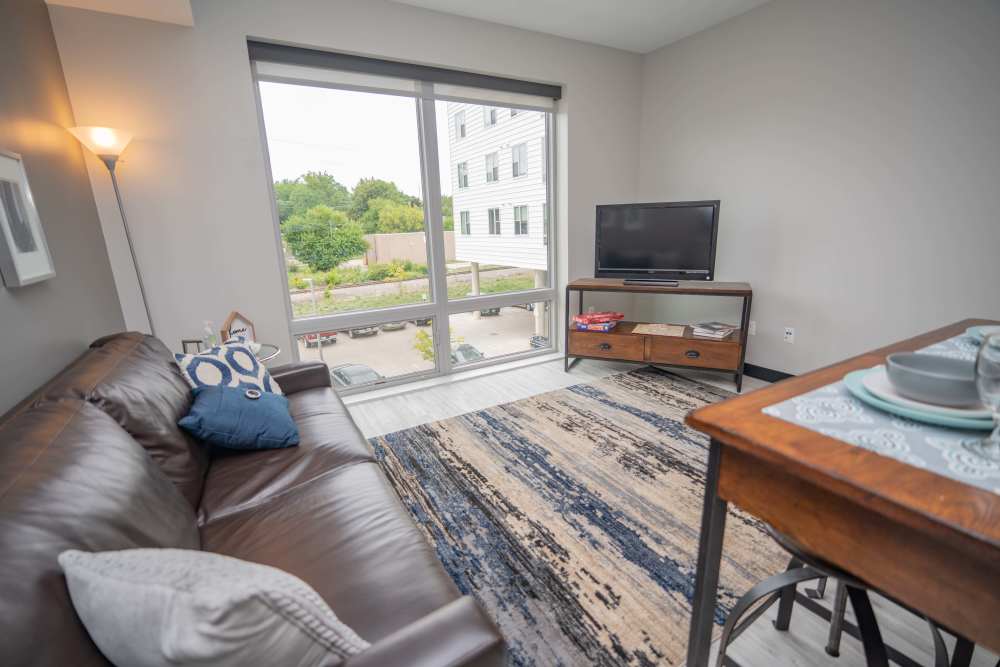  A cozy living room with a comfortable couch, coffee table, and television at Diamond Place I in Grand Rapids, Michigan
