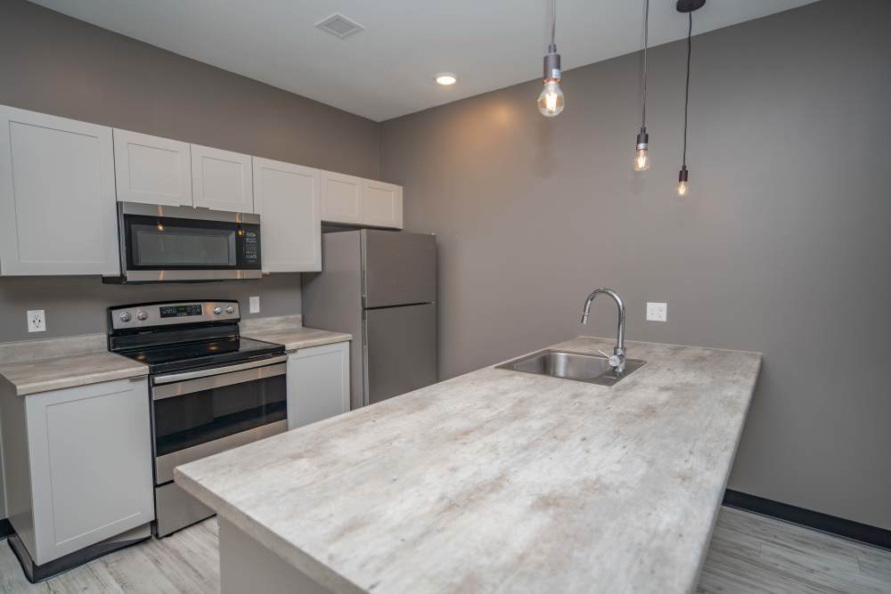 A modern kitchen with sleek stainless-steel appliances and elegant granite counter tops at Diamond Place I in Grand Rapids, Michigan
