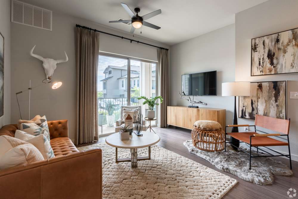 Comfortable living rom with wood floors and ceiling fan in a model home at The Trails at Summer Creek in Fort Worth, Texas