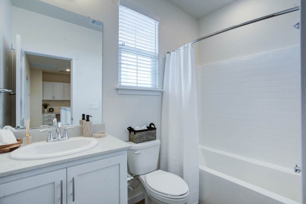 Clean and bright bathrooms with a bath tub at The Terraces at Stanford Ranch II in Rocklin, California