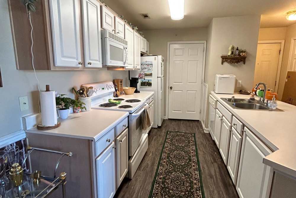 Apartment kitchen with white cabinets and appliances at The Landing at Fayetteville in Fayetteville, Arkansas