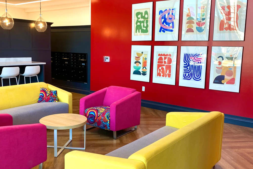 Resident lounge with pink and yellow chairs at LivRed in Lincoln, Nebraska