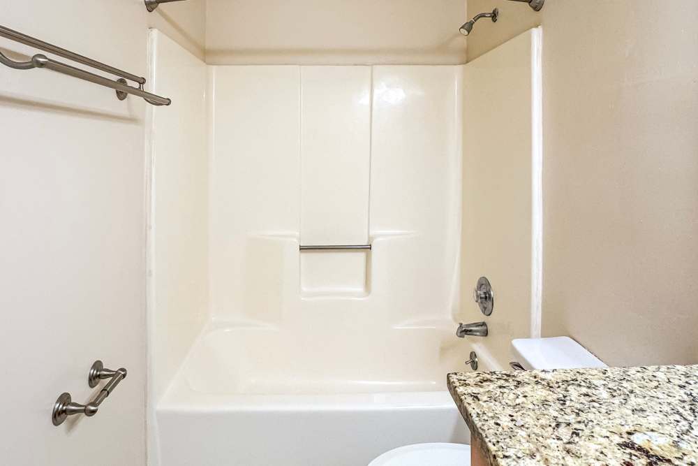 A modern bathroom with a sleek shower, a sparkling toilet, and a stylish sink at The Village on Cherokee in Columbus, Georgia