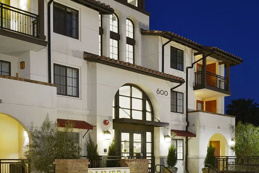 Night view of the building with lights on at Olivera Senior Apartments in Pomona, California