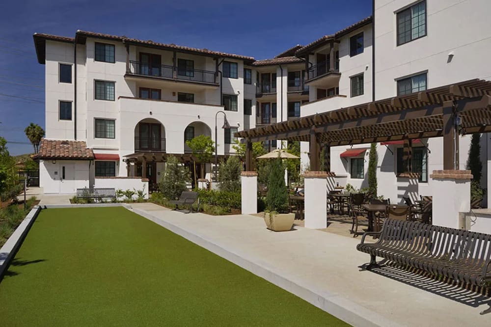 Angled view of the apartment with courtyard and lawn at Olivera Senior Apartments in Pomona, California