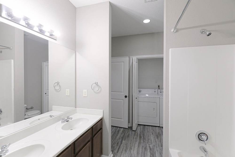 An apartment bathroom and laundry room at Aspire at Bristol Park in Grain Valley, Missouri