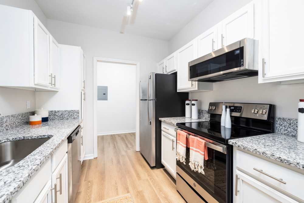 An apartment kitchen leading to the laundry room at Arbors at Cahaba River in Birmingham, Alabama