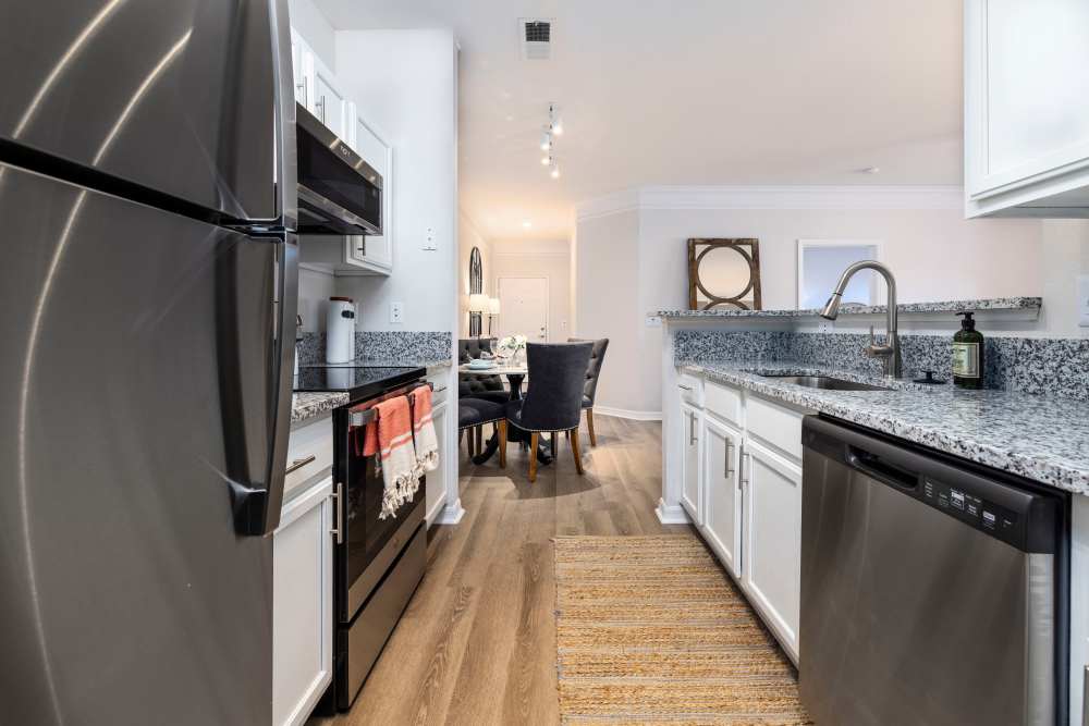 Wood flooring and stainless-steel appliances in an apartment kitchen at Arbors at Cahaba River in Birmingham, Alabama