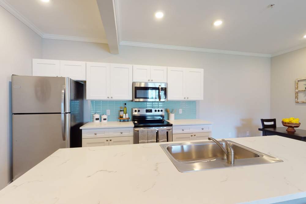 Kitchen and kitchen island with sink at Coastal Club Apartments in Brunswick, Georgia