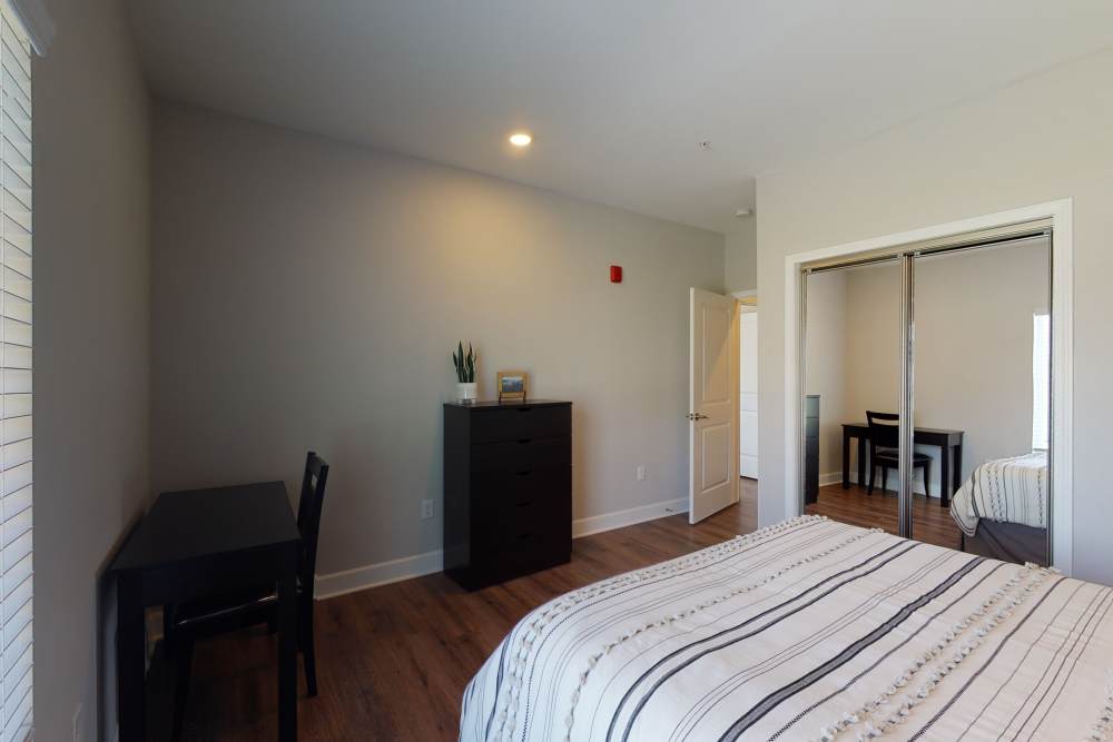Spare bedroom with wood floors and slider-door closet in a model home at Coastal Club Apartments in Brunswick, Georgia