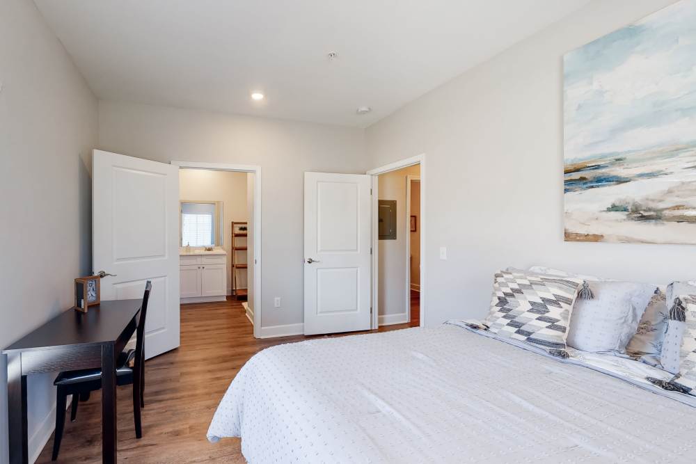 Bedroom with wood flooring and bathroom at Coastal Club Apartments in Brunswick, Georgia