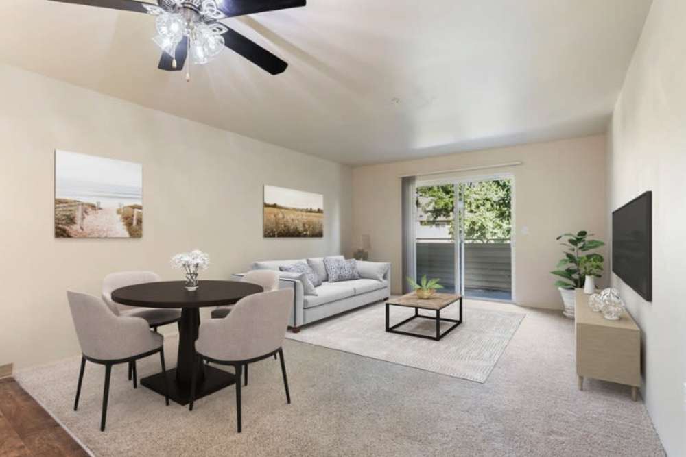 Dining table and living room with access to the balcony at Brentwood Apartments in Portland, Oregon