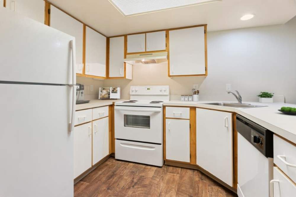 Kitchen with white appliances at Brentwood Apartments in Portland, Oregon