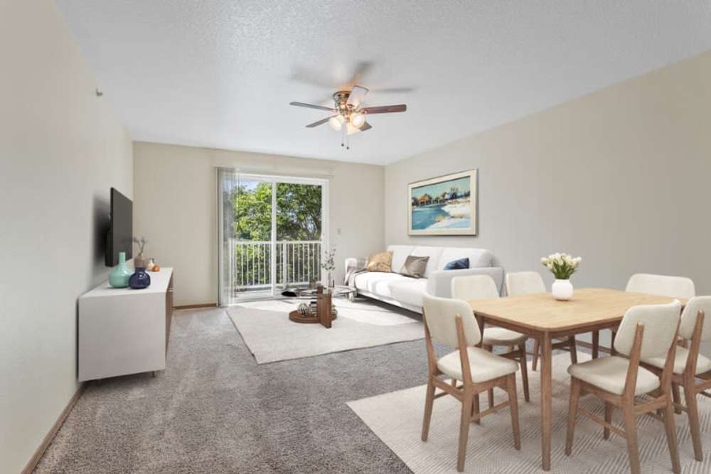 Living room with ceiling fan and door to balcony at Gateway Plaza Apartments in Portland, Oregon