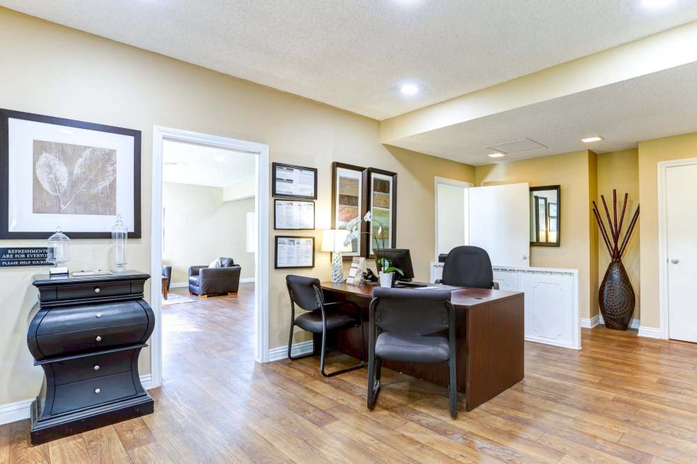 A warm-lit office room with a desk, computer and chairs at Reseda Village Green in Reseda, California