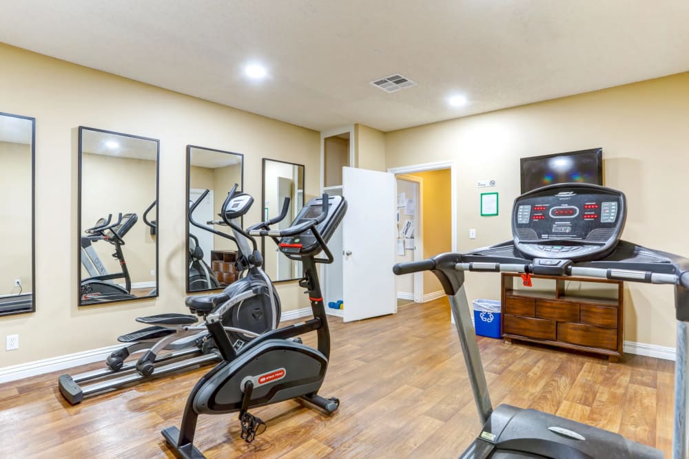 Fitness studio with treadmills and flat-screen TVs at Reseda Village Green in Reseda, California