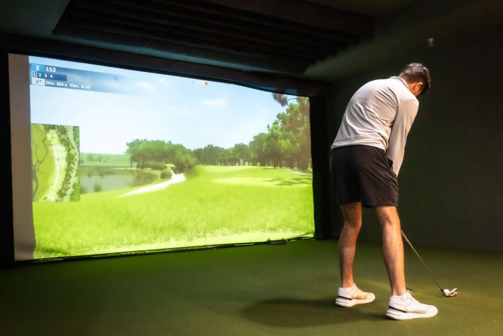 Resident using the golf simulator at College Town Oxford in Oxford, Mississippi