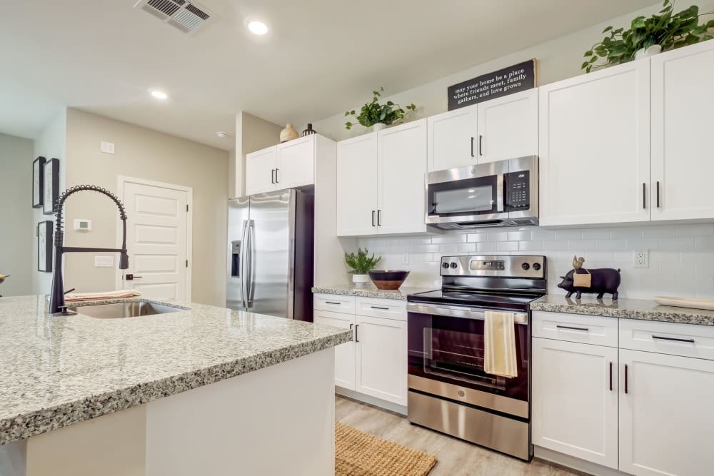 Apartment kitchen with white cabinets and granite counters at BB Living at Trails Edge in Centennial, Colorado