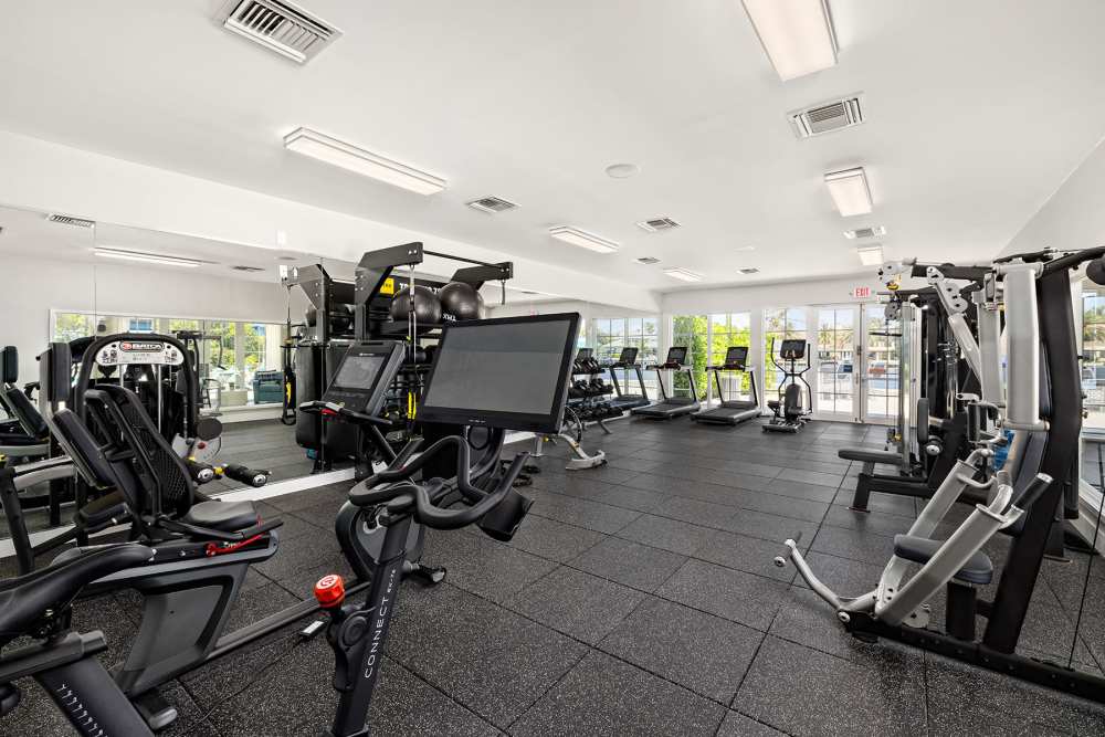 Resident fitness center with weight bench and free weights at Bermuda Cay in Boynton Beach, Florida