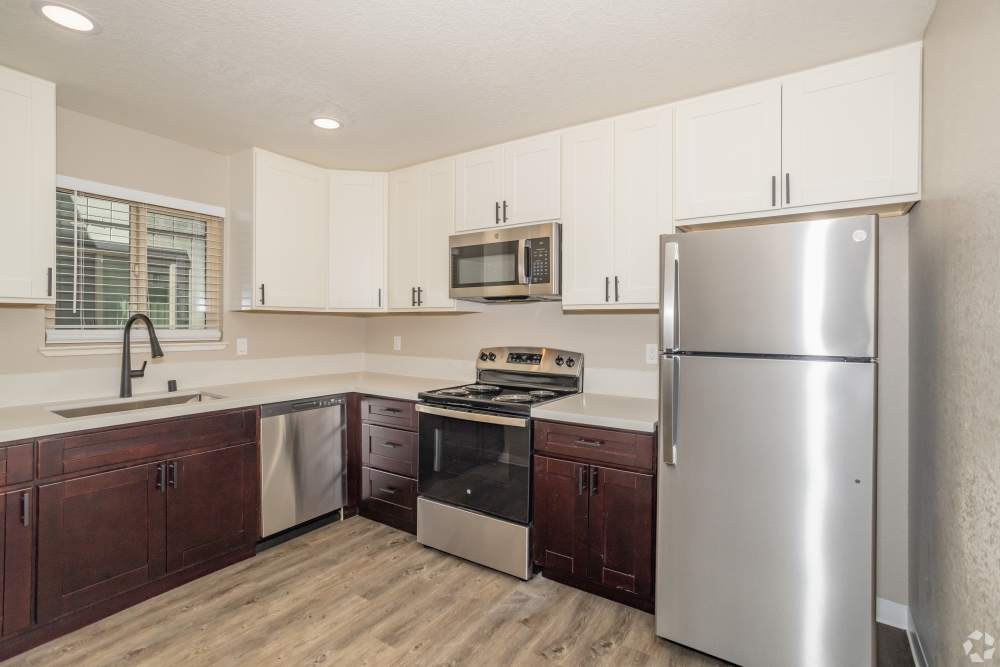 Spacious Kitchen with hanging white cabinets and appliances at El Macero Apartments in Davis, California