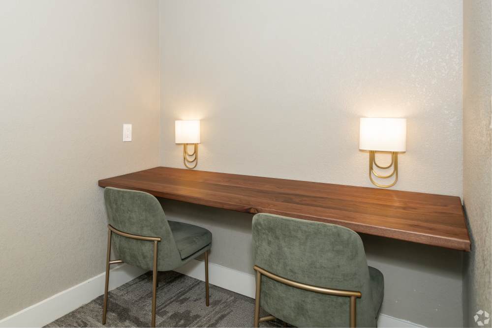 Study table with two chairs and a long table with lamps at El Macero Apartments in Davis, California