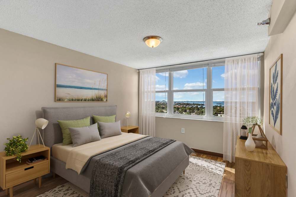 Spacious bedroom with three sunlit windows at Bay Pointe Tower in South Pasadena, Florida