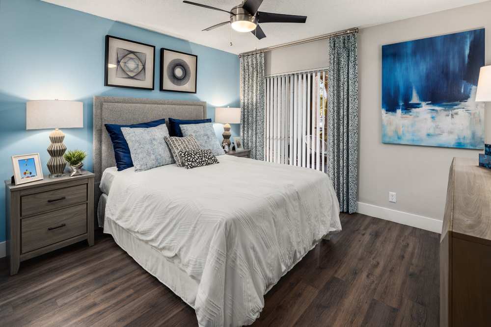 Apartment bedroom with queen-size bed and matching end tables at Boynton Place Apartments in Boynton Beach, Florida