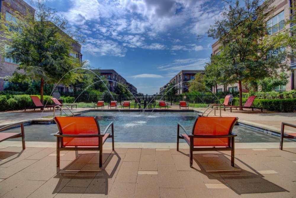 Courtyard at the park with lush greenery, benches, and a fountain at Flatiron District at Austin Ranch, The Colony, Texas