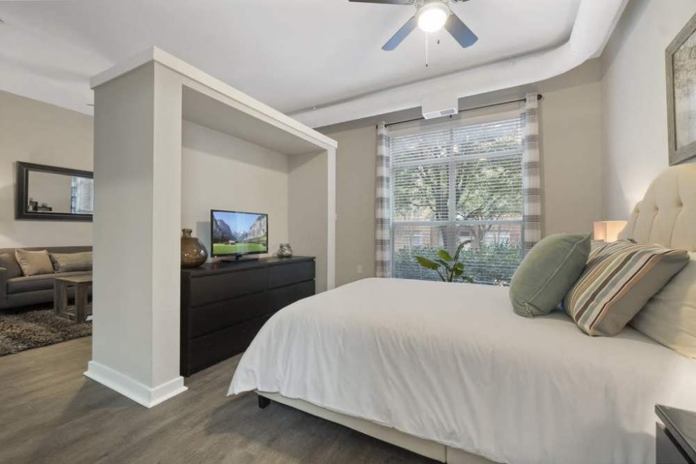 Spacious bedroom with large comfortable bed, TV, and ceiling fan at Flatiron District at Austin Ranch, The Colony, Texas