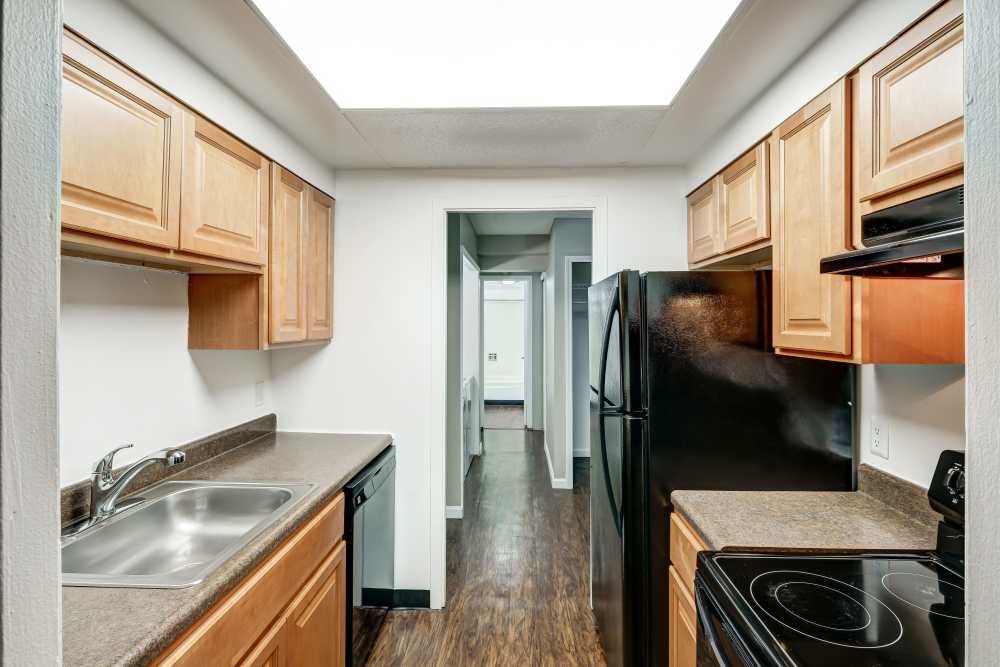Kitchen with maple cabinets and black appliances at Park Guilderland Apartments in Guilderland Center, New York