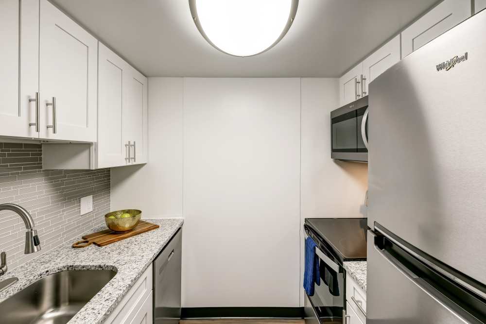 Renovated kItchen with white cabinets and stainless steel appliances at Park Guilderland Apartments in Guilderland Center, New York