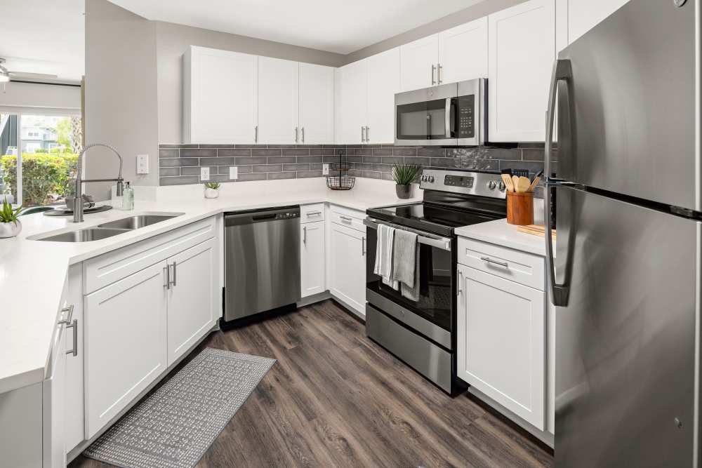 Apartment kitchen with counter seating and stainless steel appliances at Pointe Parc at Avalon in Orlando, Florida