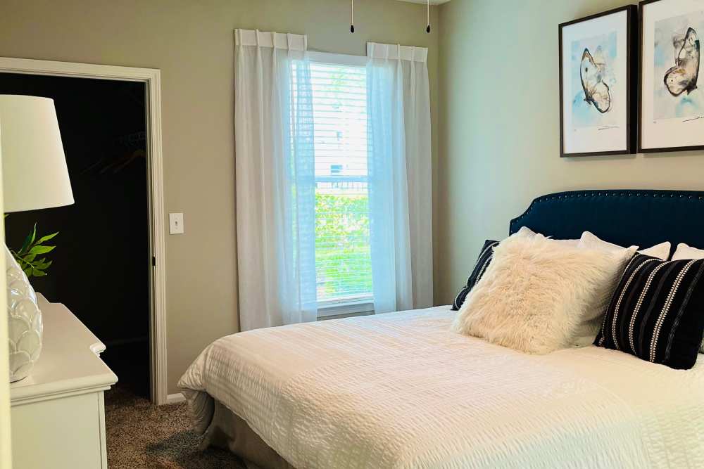 A furnished apartment bedroom with a walk-in closet at Retreat at Johns Creek in Duluth, Georgia