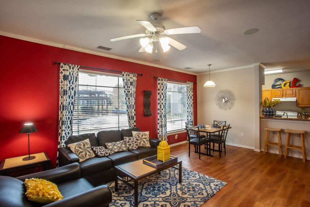 Living room with leather seating, hardwood floors, and ceiling fan at The Reserve on West 31st in Lawrence, Kansas