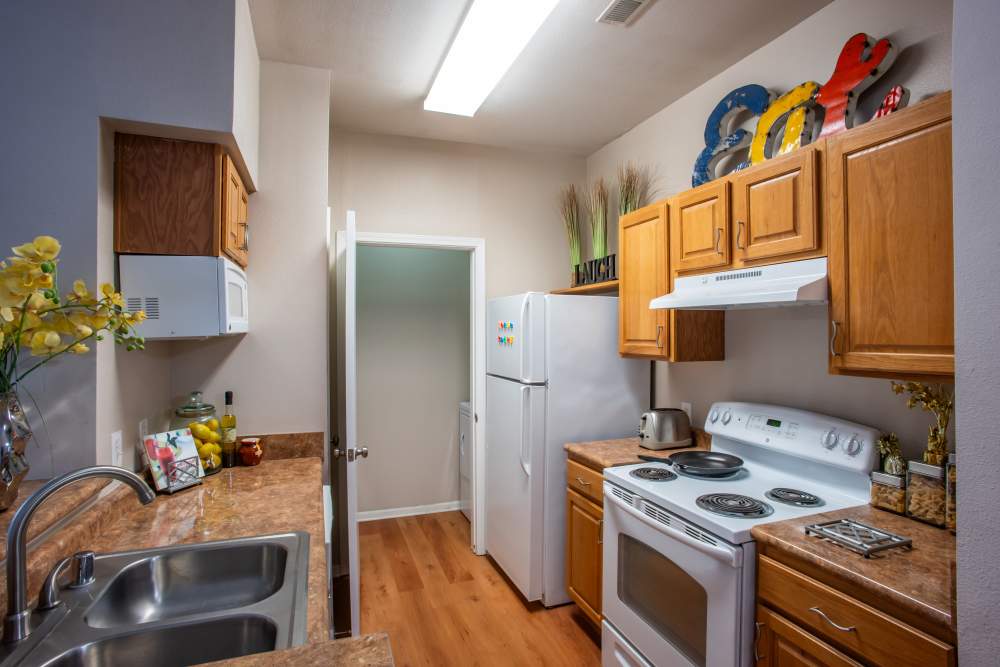 Apartment kitchen with wooden cabinets at The Reserve on West 31st in Lawrence, Kansas