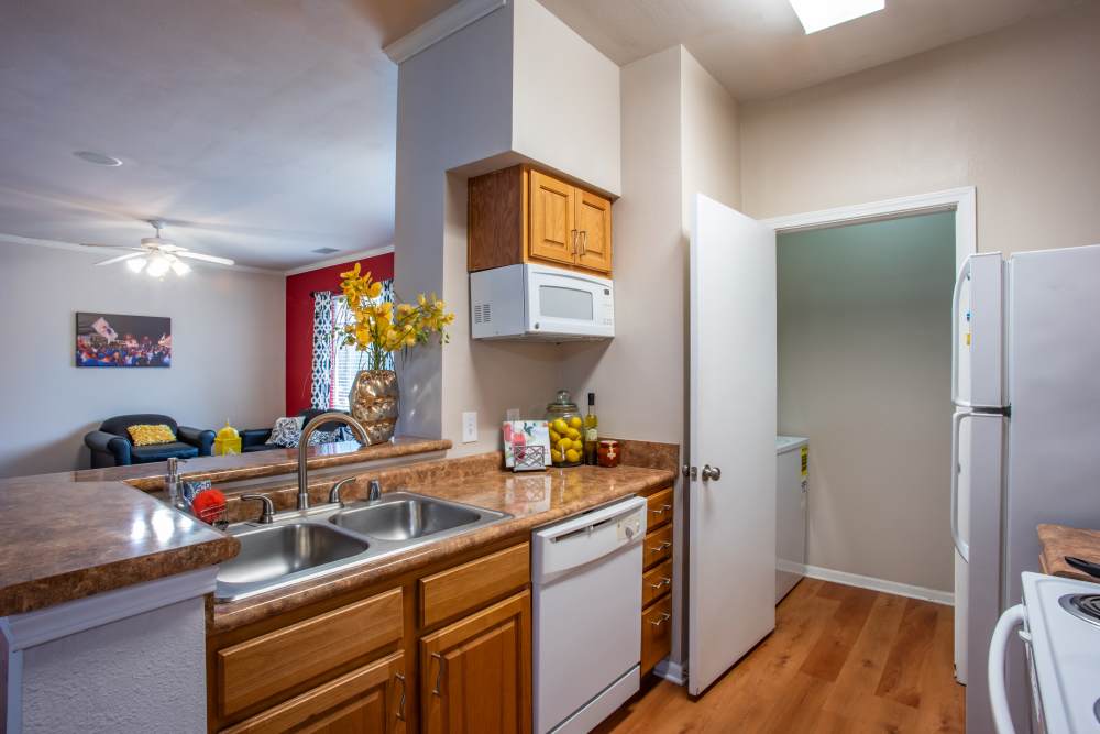 Apartment kitchen with hardwood floors and stainless-steel sink at The Reserve on West 31st in Lawrence, Kansas