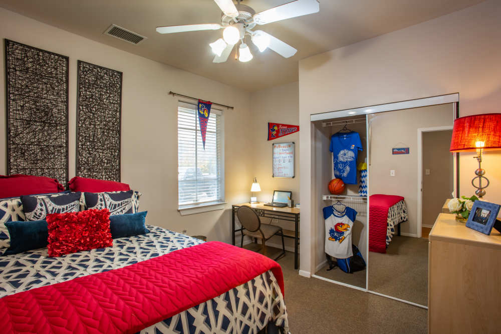 Resident bedroom with closet and ceiling fan at The Reserve on West 31st in Lawrence, Kansas