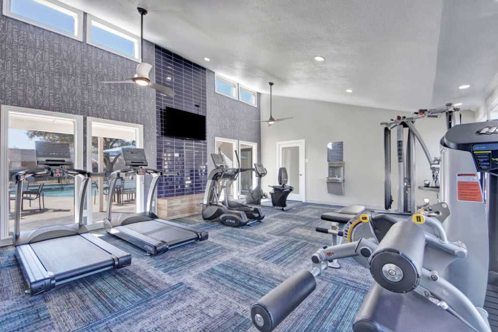 A fully equipped gym with exercise machines at The Fairway Apartments in Plano, Texas
