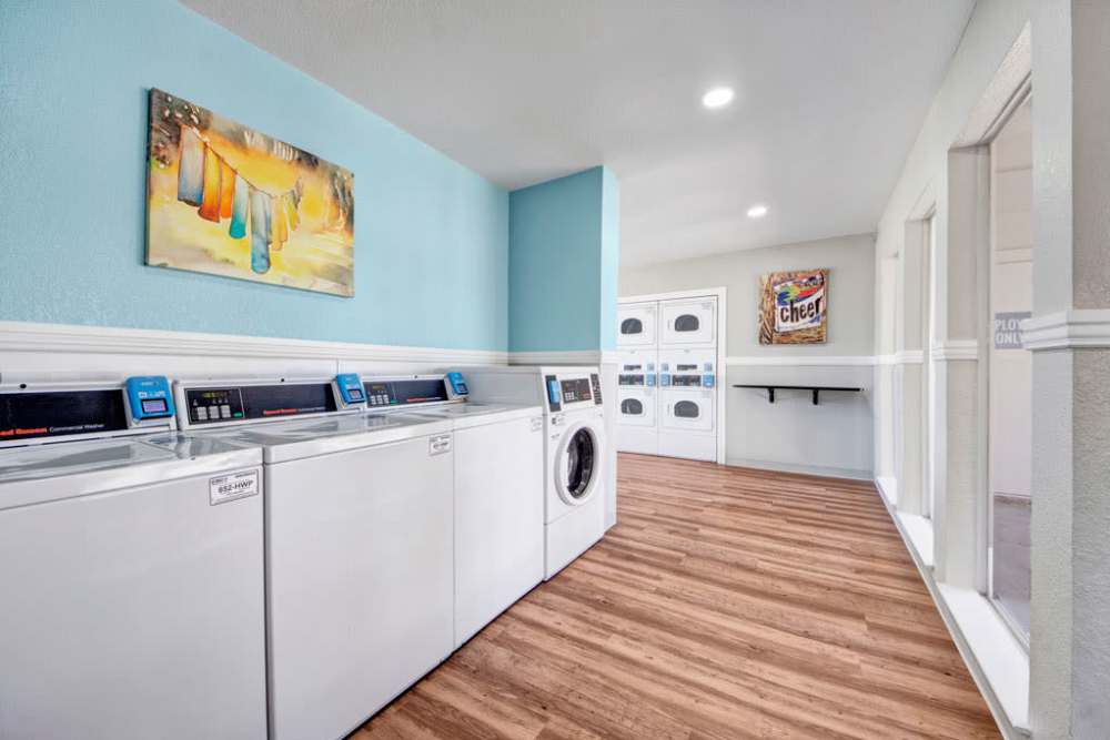 Washers and dryers in a laundry room, ready to help you tackle that pile of dirty clothes at The Fairway Apartments in Plano, Texas