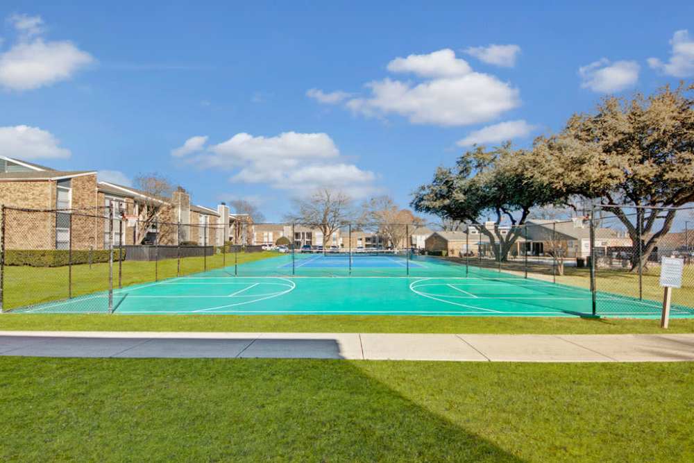 A park at the reserve with a tennis court and basketball court. Perfect for sports enthusiasts at The Fairway Apartments in Plano, Texas
