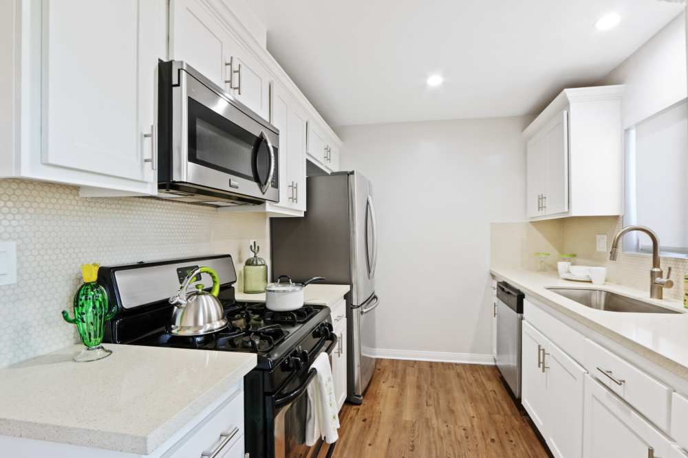 Apartment kitchen with stainless-steel appliances at Casa del Rio Seco in Downey, California