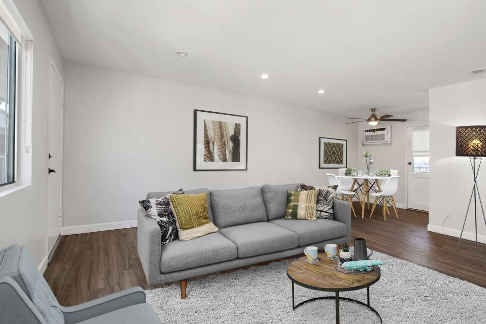 Apartment living room with wood-style flooring at Casa del Rio Seco in Downey, California